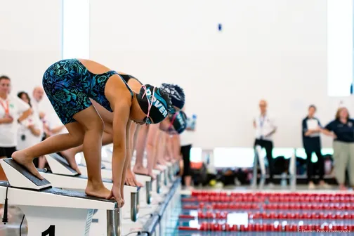 Young swimmers on the starting blocks ready to race