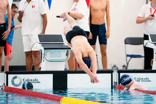 Swimmer diving into the pool at a competition